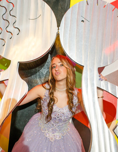 Bat mitzvah girl posing playfully through an abstract art installation at Beat Street Huntingdon Valley, PA