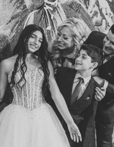 Bat Mitzvah girl with her parents and little brother smiling at her in a creative black and white photo ready to celebrate at Vie by Cescaphe in Philadelphia