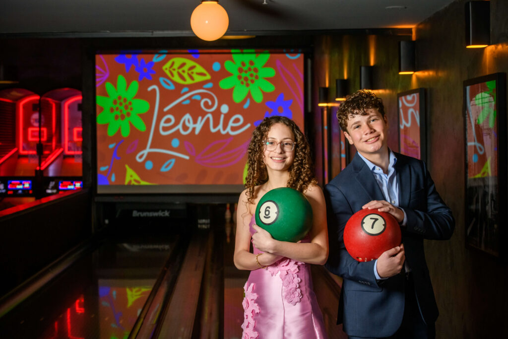 bat mitzvah girl and friend holding bowling balls in Fitler Club bowling alley Philadelphia