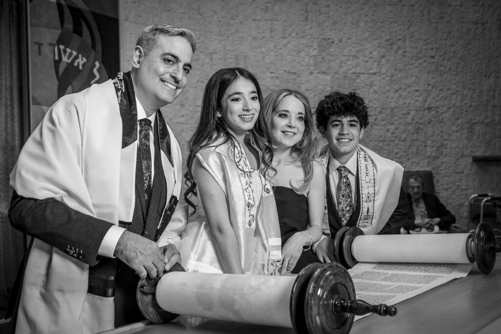 family of four posing at torah during bat mitzvah service rehearsal photos at shir ami synagogue
