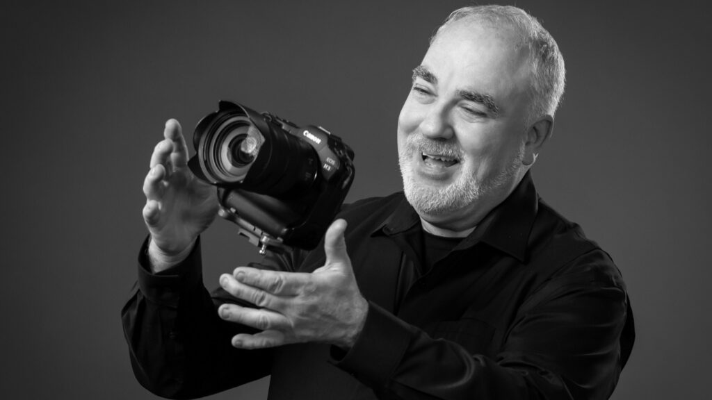 pro photographer tossing a canon camera into the air and smiling